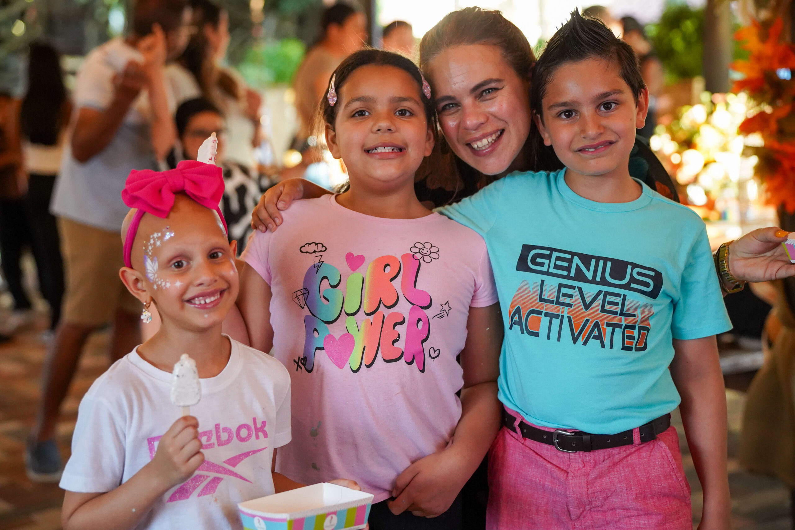 Three children with a parent at the Supreme Twins Foundation annual family fair